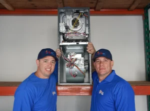 Two technicians standing with a repaired heating system